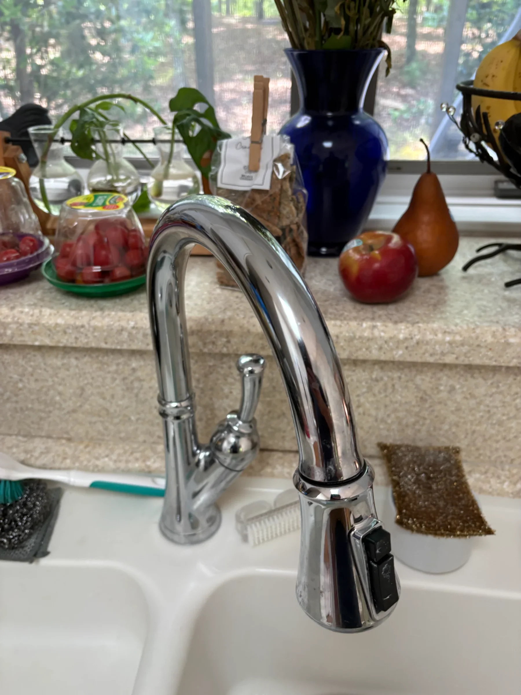 Modern kitchen faucet with a sleek design and nearby accessories in a bright, functional space.